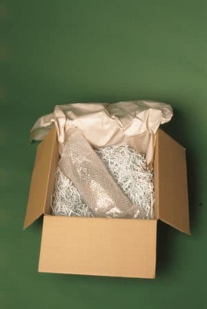 Wrapped fine art vase secured in box with packing material